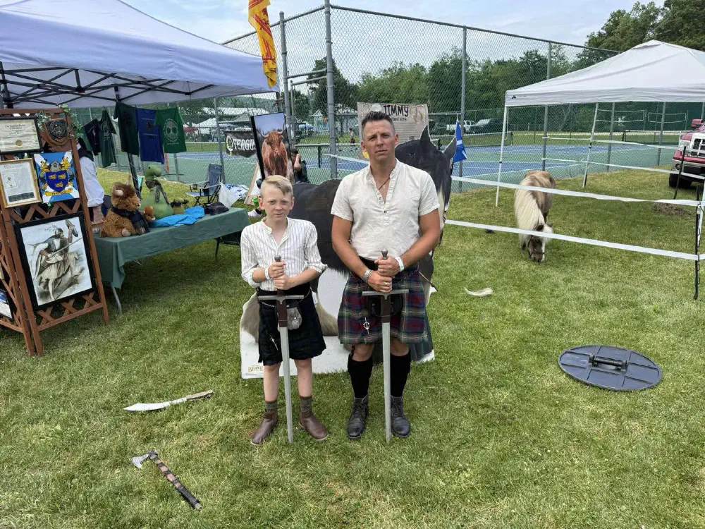 Festival visitors in kilts beside a Celtic cultural display